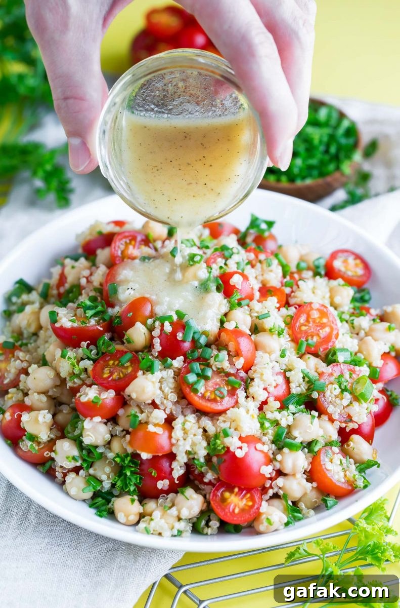 Healthy Tomato Quinoa Salad bowl with Garlic Lime Dressing poured on top