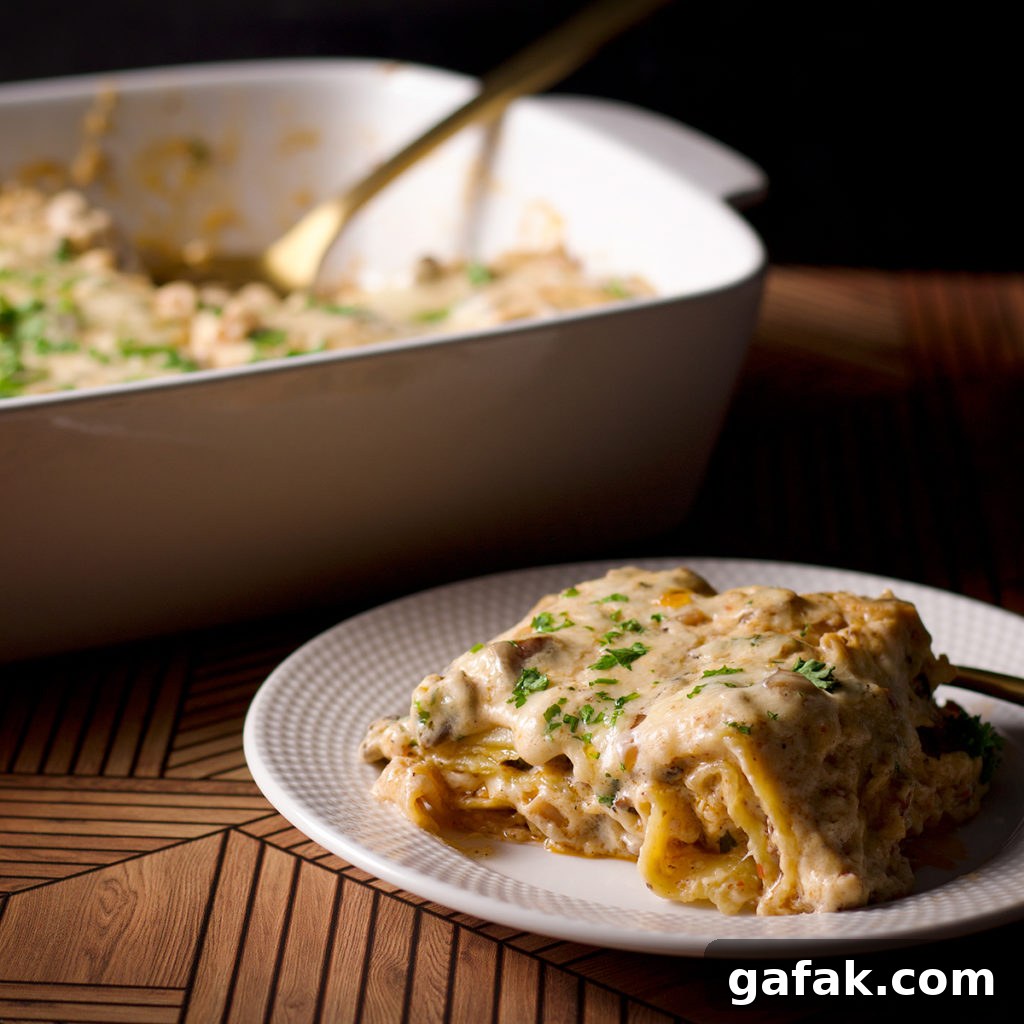 Creamy Mushroom Lasagna with Parmesan Béchamel Sauce 14 A piece of white mushroom lasagna on a plate in front of a casserole dish with the entire lasagna.