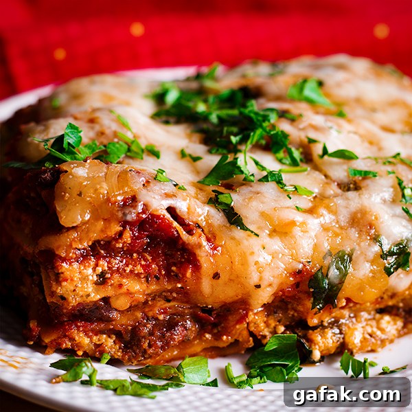 A plate of homemade classic lasagna with sausage and marinara.
