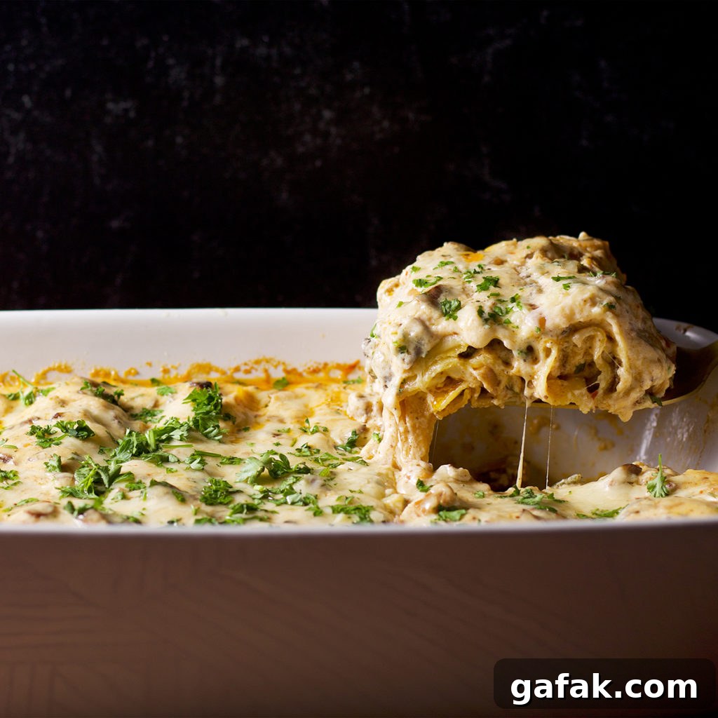 Creamy Mushroom Lasagna with Parmesan Béchamel Sauce 3 Someone using a spatula to serve a piece of white mushroom lasagna.