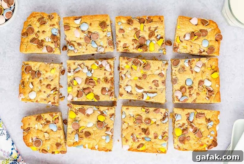 Overhead view of Cadbury tray bake bars cut into squares on parchment paper.