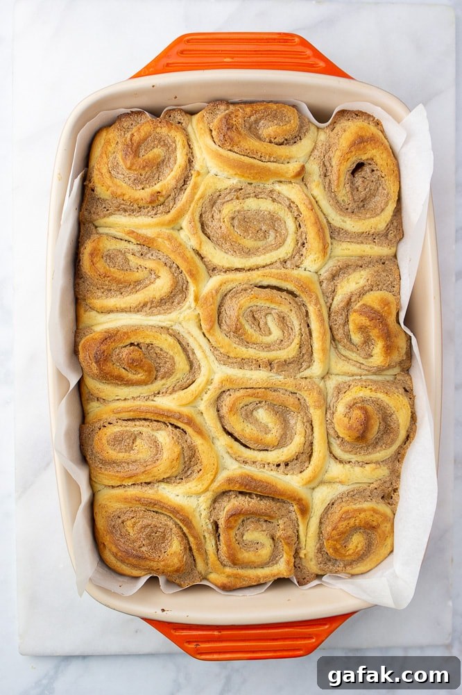 an orange baking dish of golden brown cinnamon rolls