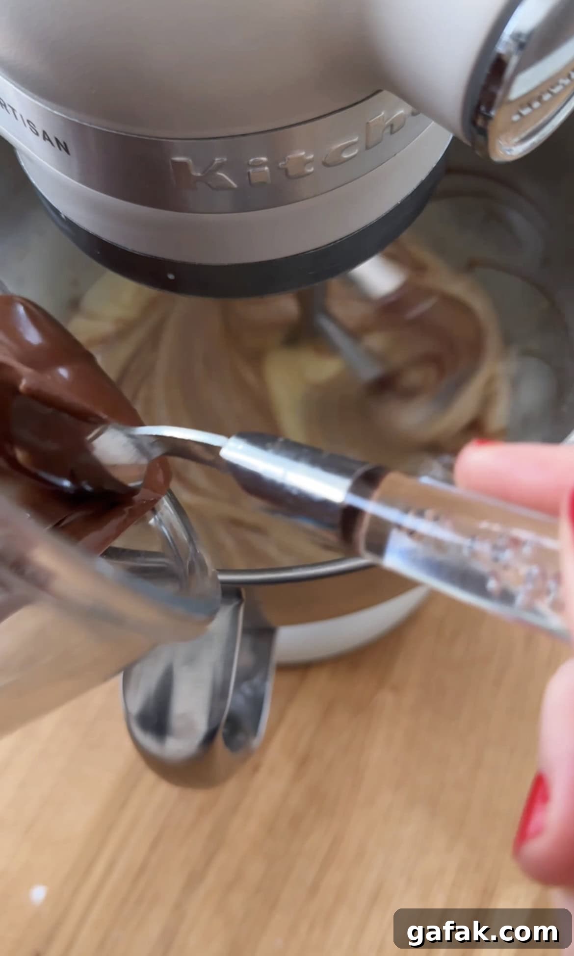 adding melted chocolate to the cake batter.