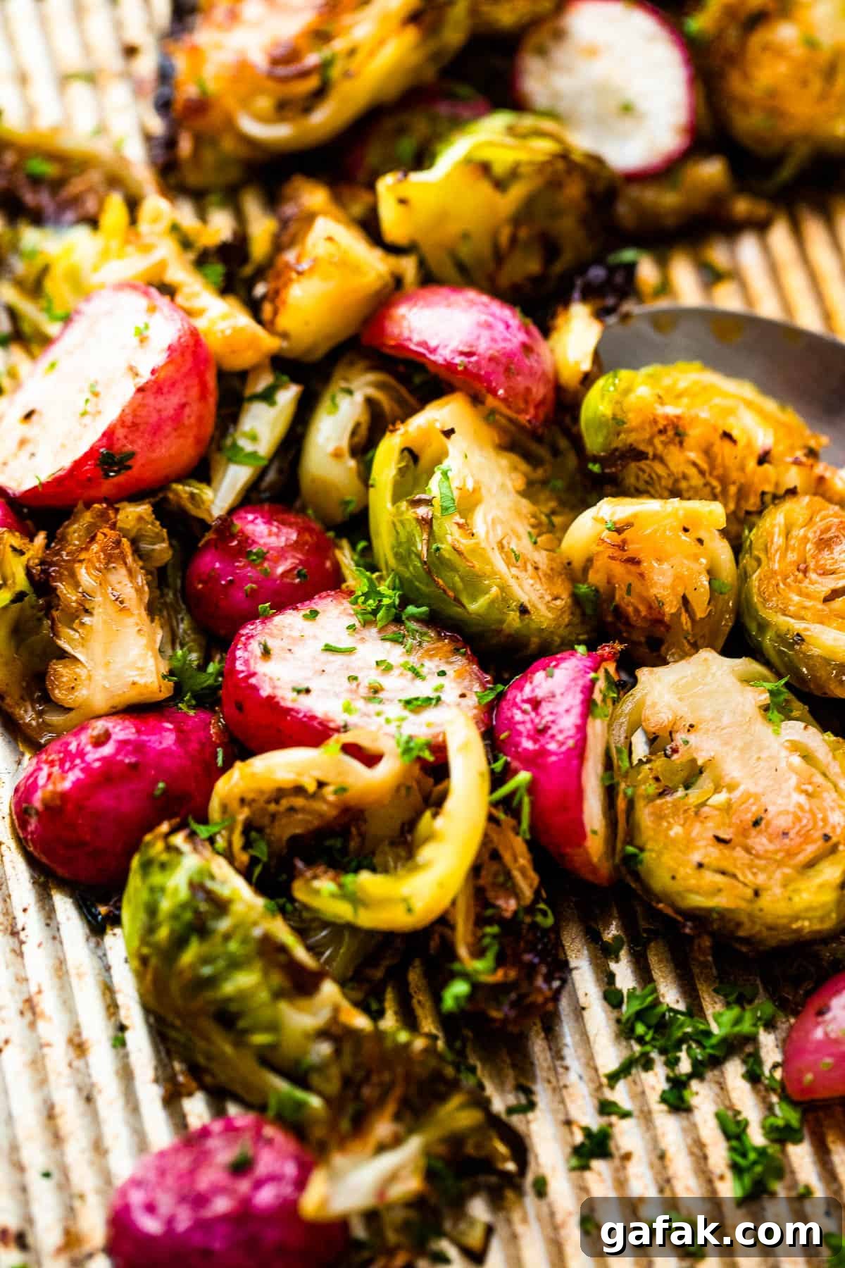 Close up shot of halved Roasted Brussels Sprouts and Radishes on a baking sheet