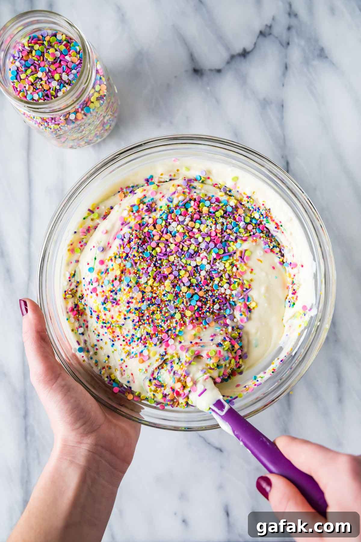 stirring sprinkles into a cheesecake batter