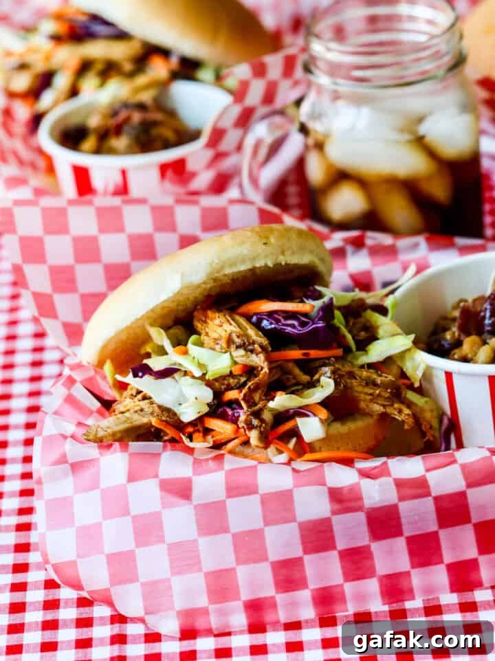 Pulled pork sandwich topped with coleslaw in a paper-lined basket.
