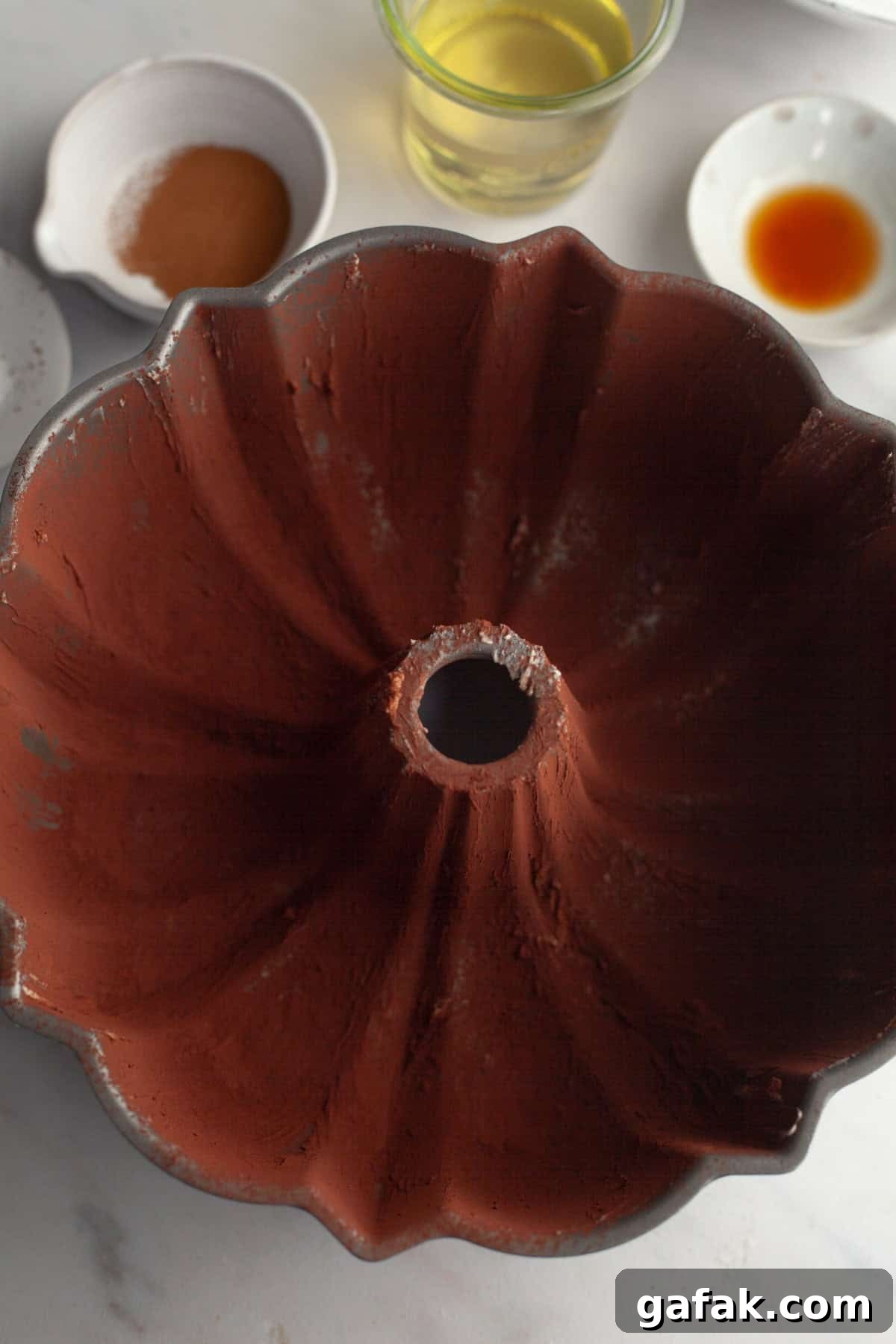 A large bundt pan covered with cocoa powder.
