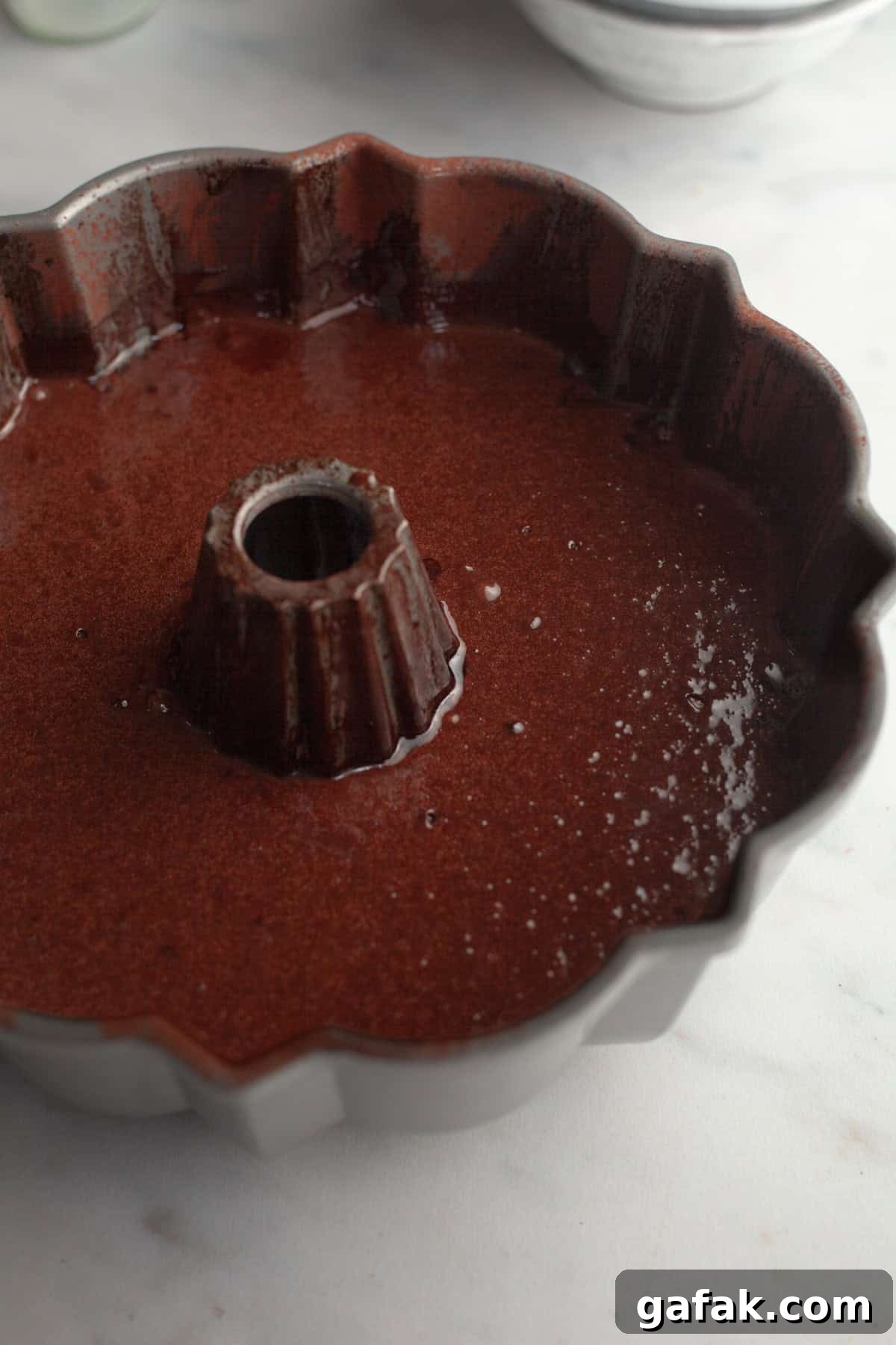 A bundt pan with unbaked chocolate cake batter.
