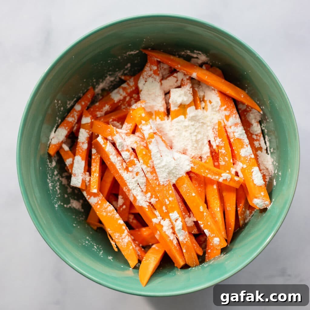 mixing toppings on sweet potato fries in bowl