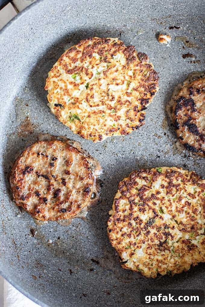 A pan showing frying cauliflower fritters and sausage patties.